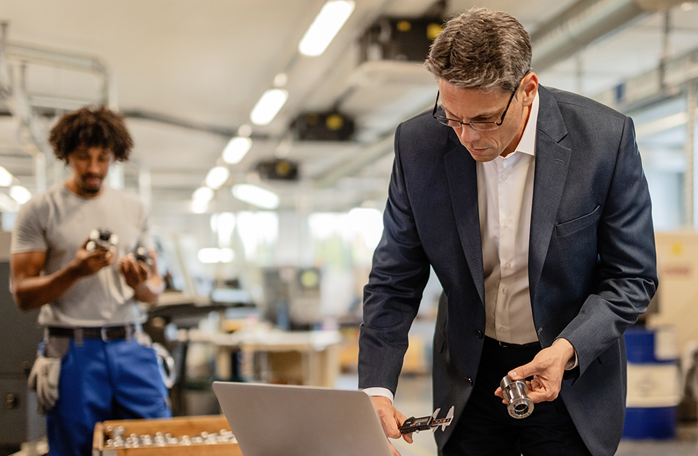 Manager from manufacturer uses computer systems to check parts info.